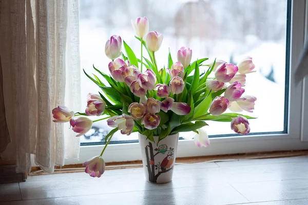 a bouquet of tulips on the windowsill by the window. pink tulip photo in defocus. tulips free space. beautiful pink tulips on a white light background