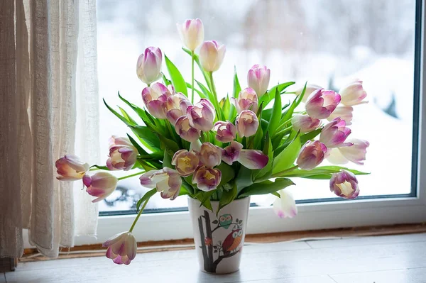 a bouquet of tulips on the windowsill by the window. pink tulip photo in defocus. tulips free space. beautiful pink tulips on a white light background