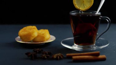 HD VIDEO 'da limon dilimli siyah ahşap masa. Soğuk sonbahar ve kış günleri için sıcak içecek. C vitamini ile soğuk algınlığını önleme kavramı