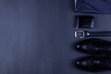 Gri bir arka planda erkek kıyafetleri ve aksesuarları olan günlük erkek kıyafetleri.