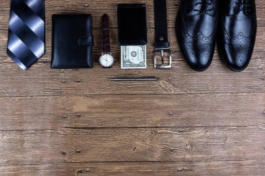 Fotokopi alanı olan düz bir iş ortamı. Erkek ayakkabıları, kol saati, cüzdan, kemer ve tahta arka planda bir kravat..