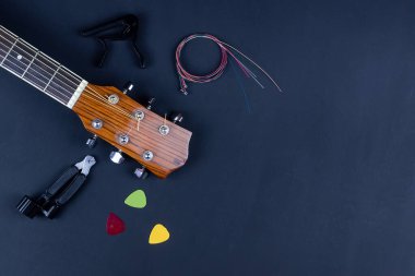 Altın akustik gitar tellerine sıkıştırılmış sarı gitar penası..