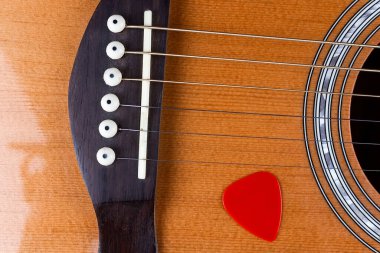 Altın akustik gitar tellerine sıkıştırılmış sarı gitar penası..