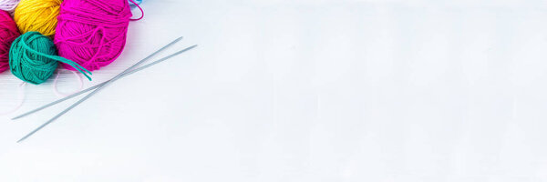 вязальный шар из пряжи и вязальных спиц на белом фоне