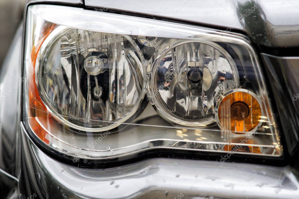 Headlight closeup of grey sporty car