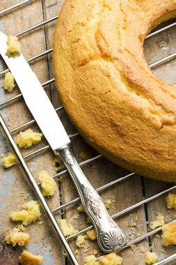 Dilimlenmiş angel food cake fırın raf gümüş bıçak yanında tarih ve rustik ahşap masa kırıntıları yakından