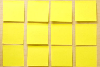 Bir ahşap tahta üzerine yapıştırılmış boş iyi bir şekilde sarı postit notlar