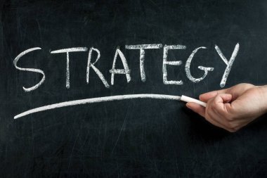 El ile Beyaz tebeşir yazı tahtası üzerinde el yazısı strateji metin altını çizme