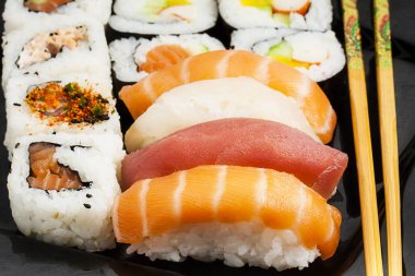 Suşi fincan siyah plaka üzerinde yemek çubukları ile yakın