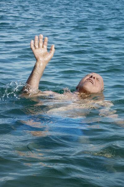 Old Man at sea drowning due to stroke and asking for help with palm upward