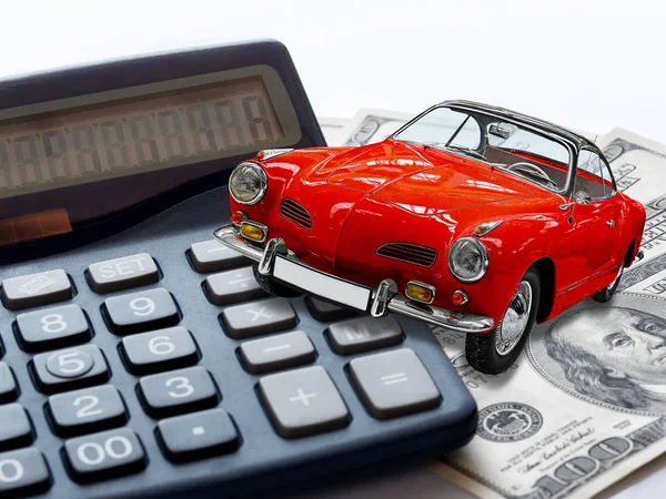 Концепція ринку автомобілів. Червоний старовинний іграшковий автомобіль на калькуляторі та 100 доларів США рахунки або банкноти — стокове фото