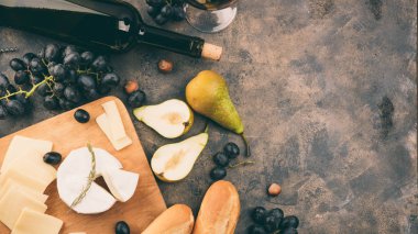 Peynir tabağı ile bir üzüm. Ahşap tahta üzerinde Camembert veya brie peyniri. Baget, şişe kırmızı şarap, armut metal arka plan üzerinde. Kopya alanı