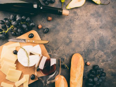 Peynir tabağı ile bir üzüm. Ahşap tahta üzerinde Camembert veya brie peyniri. Baget, şişe kırmızı şarap, armut metal arka plan üzerinde. Kopya alanı