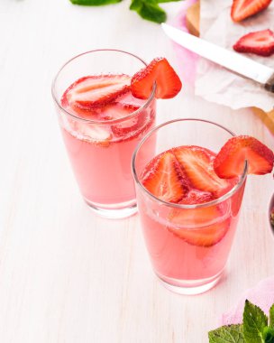 Gözlük taze pembe limonata. Ahşap bir masa üzerine nane ile çilekli soda. 