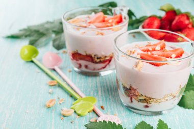 Taze çilekli yoğurt ile top. Diyet yoğurt ve granola dilim Karpuzu ahşap bir masa üzerinde bir cam ile.