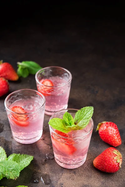 Metal masa üzerinde ev yapımı çilek likörü. Alkollü meyve kokteyli çekim bir gözlük