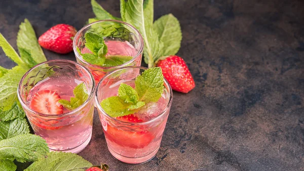 Metal masa üzerinde ev yapımı çilek likörü. Alkollü meyve kokteyli çekim bir gözlük