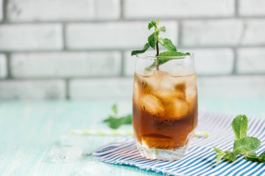 Ahşap masa üzerinde şeftalili buzlu çay bardak. Cuba Libre veya long Island buzlu çay kokteyl, soğuk bir içecek veya limonata meyve ve nane ile