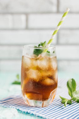 Ahşap masa üzerinde şeftalili buzlu çay bardak. Cuba Libre veya long Island buzlu çay kokteyl, soğuk bir içecek veya limonata meyve ve nane ile