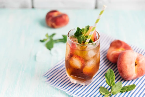 Ahşap masa üzerinde şeftalili buzlu çay bardak. Cuba Libre veya long Island buzlu çay kokteyl, soğuk bir içecek veya limonata meyve ve nane ile