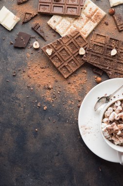 Fincan sıcak kakao veya Cappuccino ya da sütlü kahve ile hatmi bir metal rustik tepsisi masada. Çikolata, fındık, kakao tozu, metniniz için kopya alanı