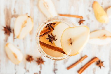 Cam elma armut kokteyl veya limonata, tarçın sopa, anason Beyaz ahşap arka plan üzerinde yıldız.