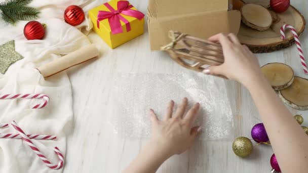 Frauenhände Wickeln Geschenk Spielzeugschlitten Luftpolsterfolie Und Legen Sie Eine Schachtel — Stockvideo