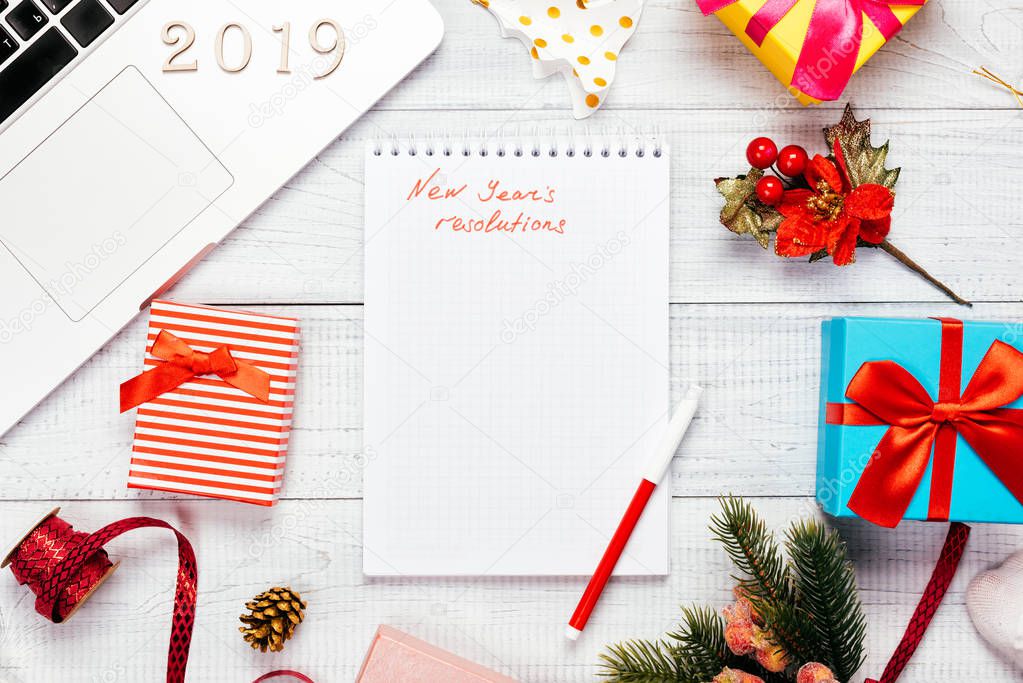 New years resolutions. Laptop with Christmas decorations and gifts on wooden table. Christmas mock up template. Home office workspace. 2019 New Year