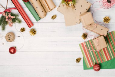 Noel hediyeleri ve kraft kağıt ahşap bir masa, köknar-ağaç dalları ve dekorasyon, üstten görünüm üzerinde hediye kutuları sarılı. Yat, metin için yer Kopyala.