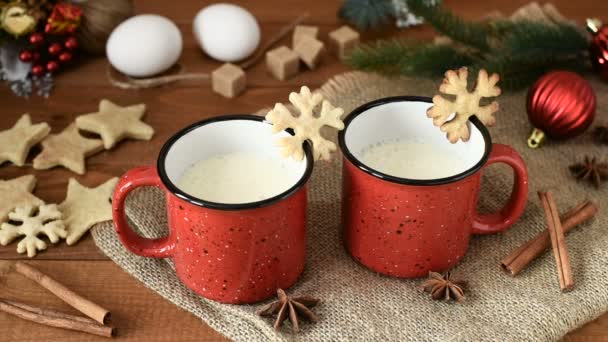 传统的圣诞饮料蛋 星和磨碎的肉豆蔻在红色的杯子在木桌上 根子书 鸡蛋和冷杉装饰 — 图库视频影像