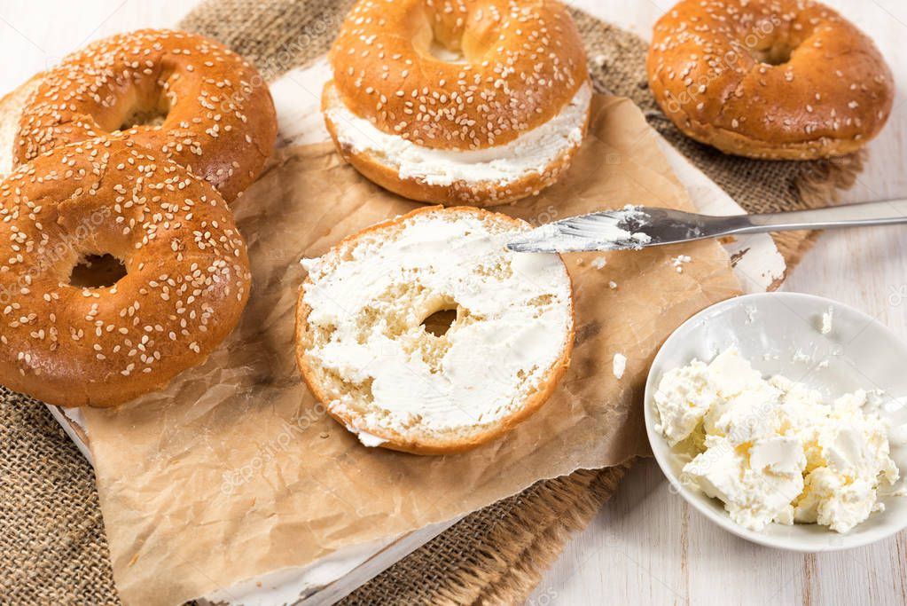 Fresh homemade bagel sandwiches with low fat cream cheese. Healthy breakfast food on rustic wooden background