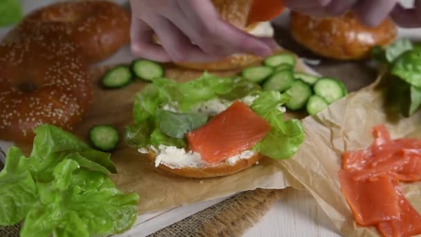 新鲜自制的百吉饼三明治 配烟熏三文鱼 低脂奶油奶酪和鸡蛋 乡村木制背景的健康早餐食品 — 图库视频影像