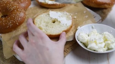 Taze ev yapımı simit sandviç somon füme ve az yağlı krem peynir ve yumurta ile. Sağlıklı kahvaltı gıda rustik ahşap zemin üzerine