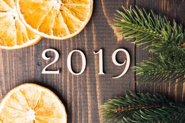Ahşap basamak numara 2019 üzerinde ahşap arka plan portakal ve köknar ağacı dalları ile şekillendirme oyulmuş. Yeni yıl sembolü, üstten görünüm