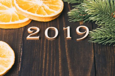 Ahşap basamak numara 2019 üzerinde ahşap arka plan portakal ve köknar ağacı dalları ile şekillendirme oyulmuş. Yeni yıl sembolü, üstten görünüm