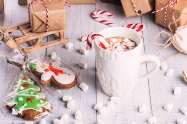 Fincan kakao ya da çikolata ahşap Noel arka plan üzerinde. Kış sıcak çikolata meşrubatının Marshmallow, kardan adam ve bir çam ağacı kurabiye, baston şekerler