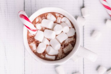 Fincan kakao ya da çikolata ahşap Noel arka plan üzerinde. Kış sıcak çikolata meşrubatının Marshmallow, kardan adam ve bir çam ağacı kurabiye, baston şekerler