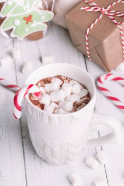 Fincan kakao ya da çikolata ahşap Noel arka plan üzerinde. Kış sıcak çikolata meşrubatının Marshmallow, kardan adam ve bir çam ağacı kurabiye, baston şekerler