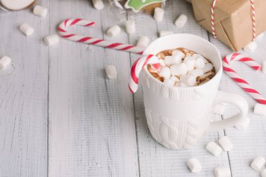 Fincan kakao ya da çikolata ahşap Noel arka plan üzerinde. Kış sıcak çikolata meşrubatının Marshmallow, kardan adam ve bir çam ağacı kurabiye, baston şekerler