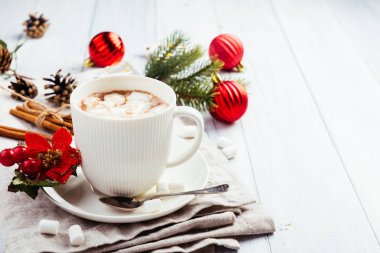 Sıcak çikolata hatmi ve tarçın ile beyaz ahşap masanın üzerine yapışır. Kış peçeteye, Noel ağacı kakao içki altın yıldız ve kırmızı topları süslemeleri, dalları ve koniler