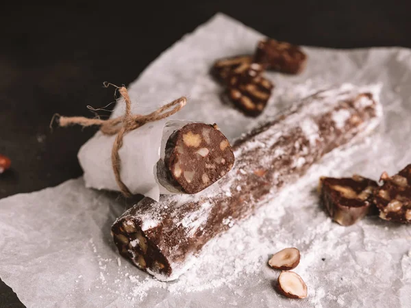 Ahşap zemin üzerine çikolata salamı. Tatlı bisküvi ve fındık tatlı krema şeker dökülen