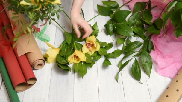 Mani Femminili Della Marca Fiorista Mazzo Bei Fiori Giallo Orchidee — Video Stock