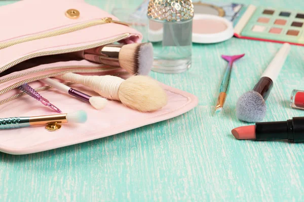 Sac de maquillage rose avec des cils et des cosmétiques décoratifs sur le bureau féminin . — Photo