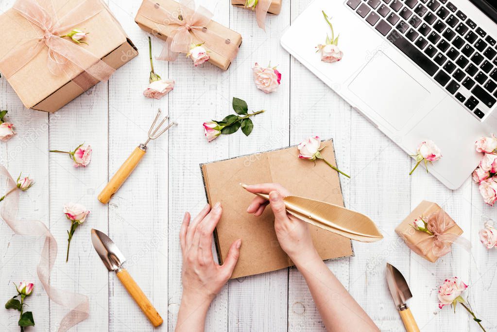 Workspace with a laptop keyboard, rose flowers, gift boxes