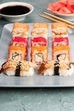 Suşi rulo ve sashimi siyah bir taş plaka.