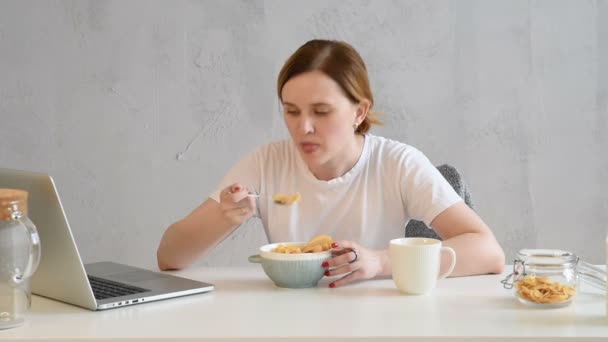 Mujer Rubia Joven Cansada Soñolienta Con Camiseta Blanca Desayuna Copos — Vídeos de Stock
