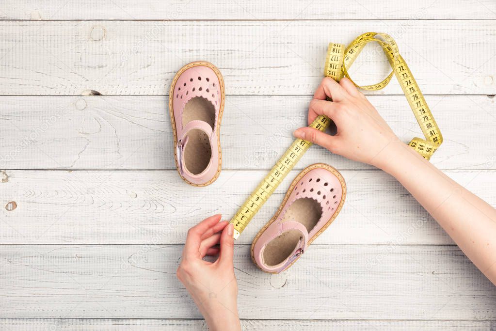 Female hands hold Summer Pink Baby girl shoes 
