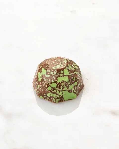 Exclusive handcrafted chocolate candy on white marble background.