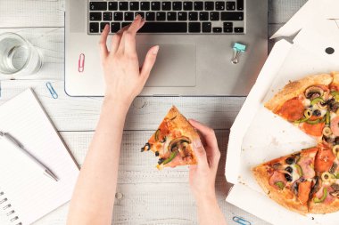 İş kadını bir dizüstü bilgisayar ile bir ofis masası çalışan ve bir öğle yemeği