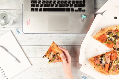 İş kadını bir dizüstü bilgisayar ile bir ofis masası çalışan ve bir öğle yemeği